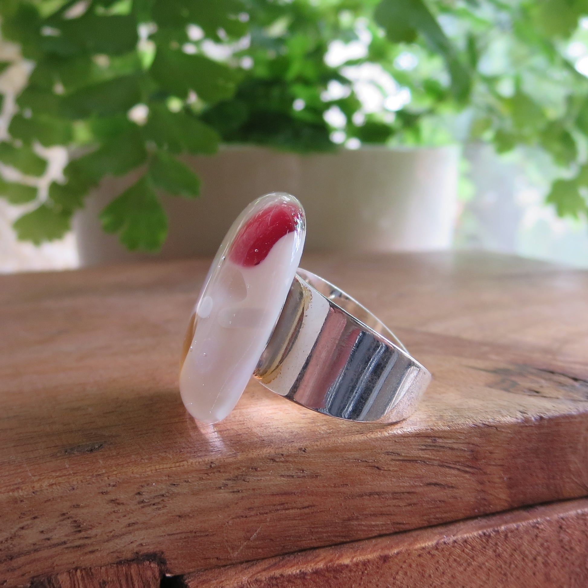 Side view of ring with plant in background. handmade by Pamela Angus 